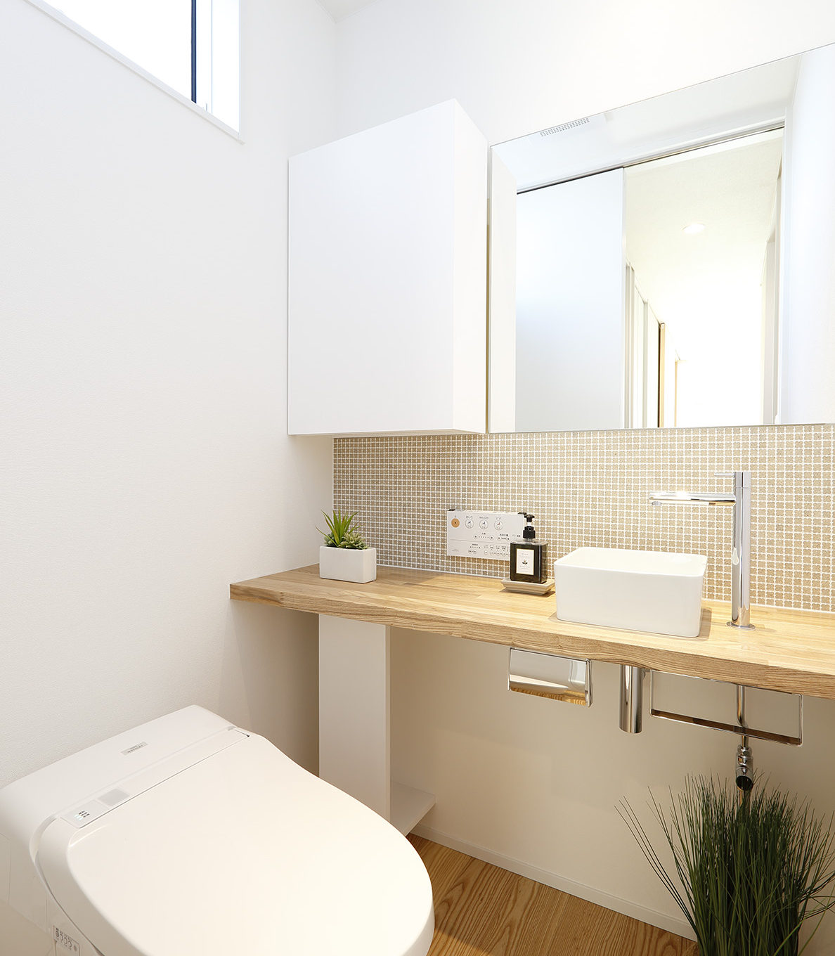 トイレ手洗いカウンターは造作です。 インテリアに合わせて空間を演出できる設計とアクセントにモザイクタイルを敷いています。