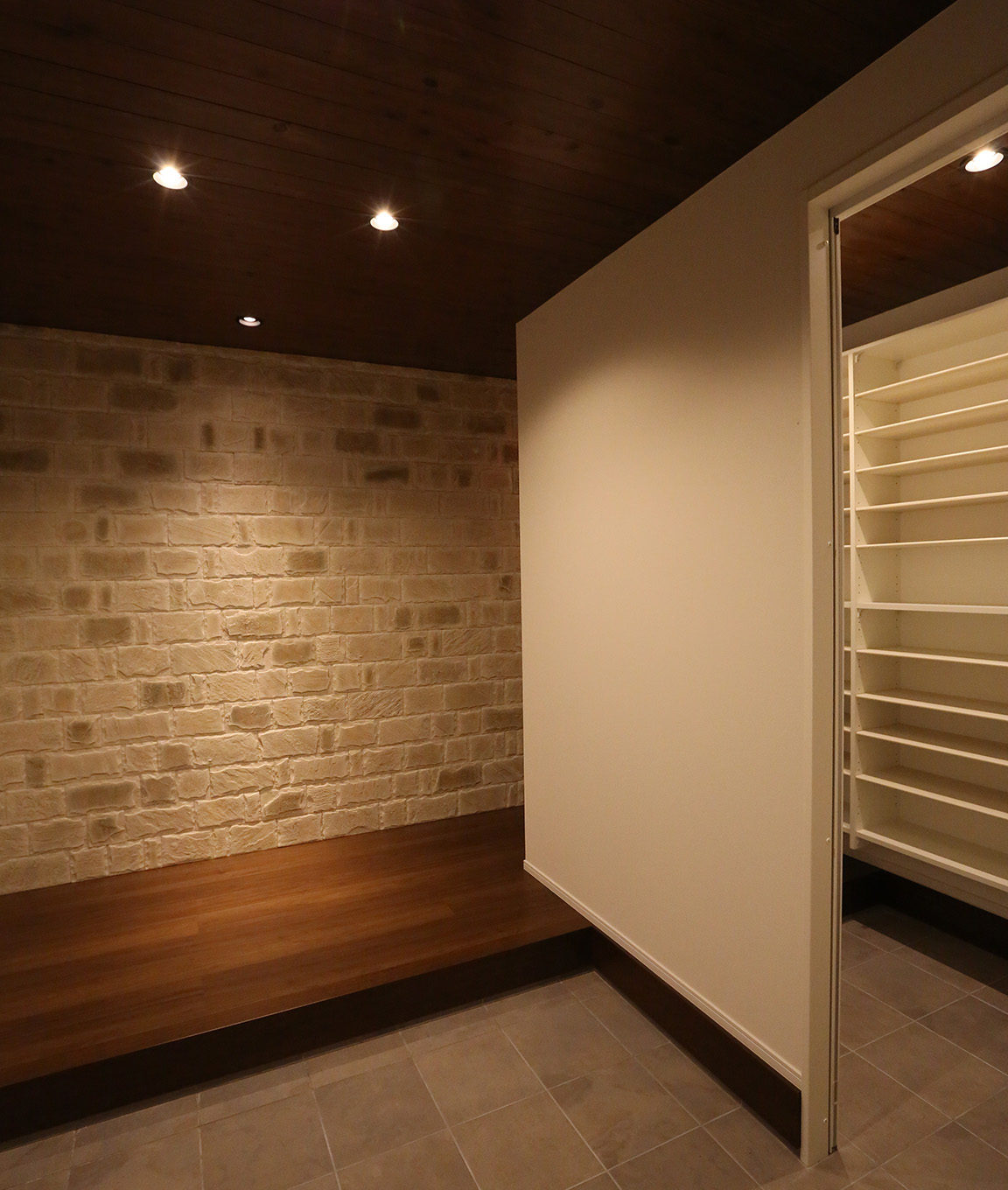 玄関・靴室　：　壁にはアクセントのタイル、天井は塗装された杉板を使用。